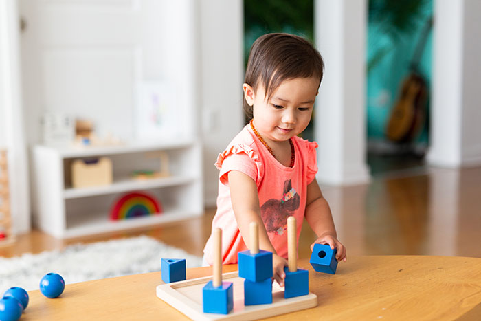 Toddler Girl Playing and Exploring with Montessori Lessons at a Preschool & Daycare Serving Brighton, MI