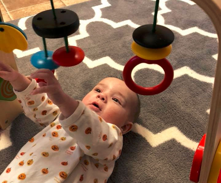 baby playing with wooden toy at a Preschool & Daycare Serving Brighton, MI