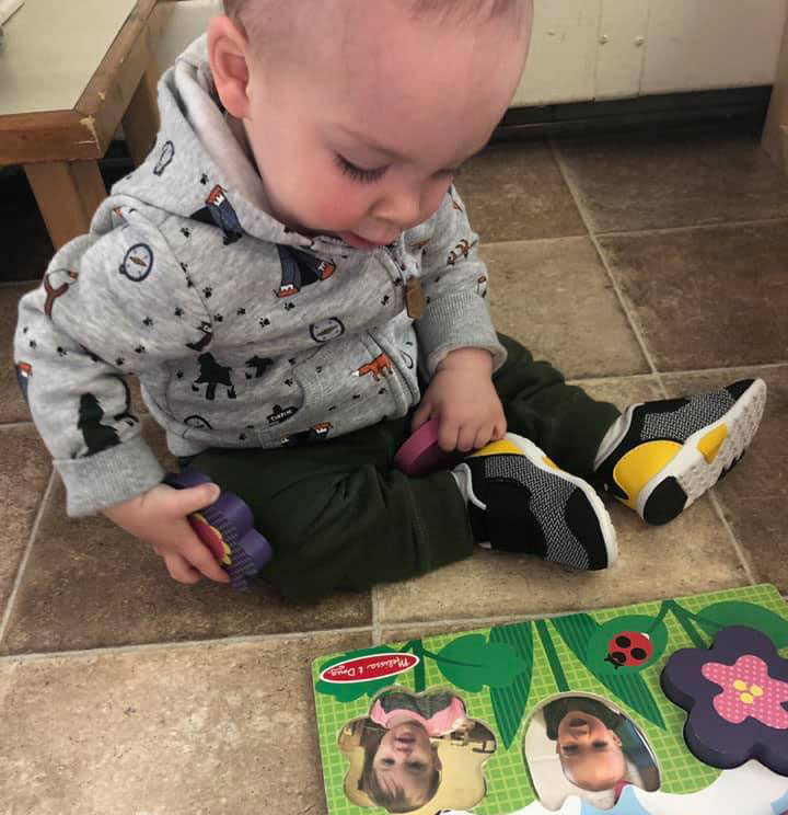 baby playing with wooden toy at a Preschool & Daycare Serving Brighton, MI