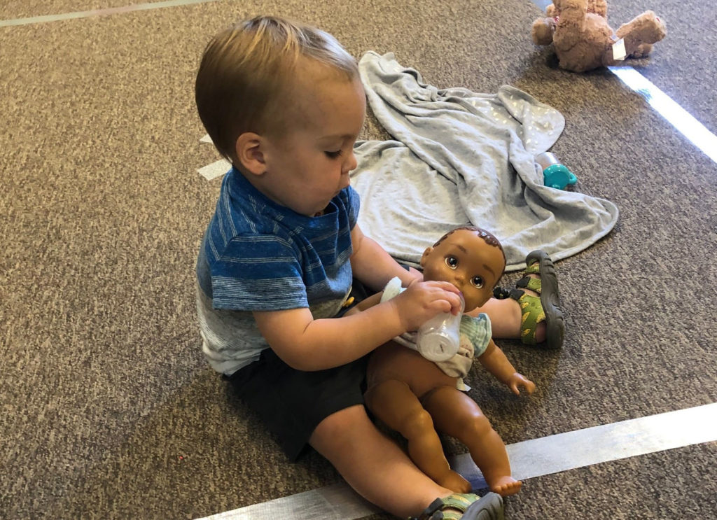 infant playing with doll at a Preschool & Daycare Serving Brighton, MI